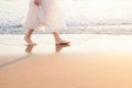 Beautiful woman walk on the beach with sea surf at sunset Royalty Free Stock Photo