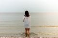 Woman walking along beach and sea sunset background.Loneliness and sadness concept.Empty place for text.Back view Royalty Free Stock Photo