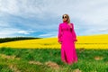 Beautiful women walking in amazing field of yellow rapeseed in the countryside. Canola oil plants Royalty Free Stock Photo