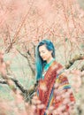 Beautiful woman walking among blooming trees.