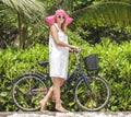 Beautiful woman walking with bycycle on beach vacation