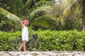 Beautiful woman walking with bycycle on beach vacation