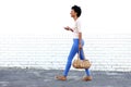 Beautiful woman walking and listening to music with purse Royalty Free Stock Photo