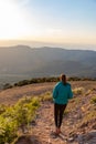 Beautiful woman walking on a path during sunset with mountains on the background Royalty Free Stock Photo