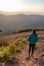 Beautiful woman walking on a path during sunset with mountains on the background Royalty Free Stock Photo