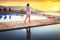 Beautiful woman walking at the pool at sunrise in Greece