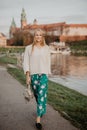 Beautiful blonde young woman walking beside the river at sunset. Her Hair blowing in the wind Royalty Free Stock Photo