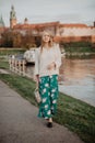 Beautiful blonde young woman walking beside the river at sunset. Her Hair blowing in the wind Royalty Free Stock Photo