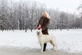 Beautiful woman walking with White Swiss shepherd dog in winter Royalty Free Stock Photo