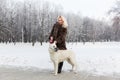 Beautiful woman walking with White Swiss shepherd dog in winter Royalty Free Stock Photo