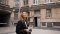 Beautiful woman walks around city and takes photos of old architecture. Action. Female photographer takes pictures of