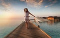 Beautiful woman walks down a wooden jetty on the Maldives Royalty Free Stock Photo