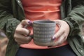 Beautiful woman wanders in the autumn forest and drinks coffee