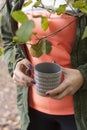 Beautiful woman wanders in the autumn forest and drinks coffee