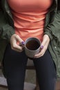 Beautiful woman wanders in the autumn forest and drinks coffee