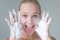 Beautiful woman washing her face with water and suds smiling. Hygiene and beauty skincare