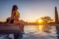 Beautiful woman watching the sunset sitting on swimming pool Royalty Free Stock Photo