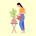 Beautiful woman watering houseplant. Caring for home plants. Hobby
