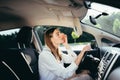 Beautiful woman watermelon in the car corrects makeup looking in the mirror before the trip