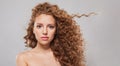Beautiful woman with wavy hair and natural makeup. Young fashion model with long curly hairstyle and fresh clear skin posing Royalty Free Stock Photo
