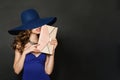 Beautiful Woman Wearing Blue Evening Goun and wide blue hat. Female with  Brown Hair, Clutch Handbag and Jewelry Necklace Royalty Free Stock Photo