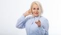 Beautiful woman wearing blue shirt standing over white isolated background smiling doing talking on the telephone gesture and Royalty Free Stock Photo