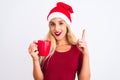 Beautiful woman wearing Christmas Santa hat drinking coffee over isolated white background surprised with an idea or question Royalty Free Stock Photo