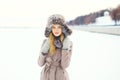 Beautiful woman wearing a coat and hat over snow in winter Royalty Free Stock Photo