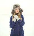 Beautiful woman wearing a coat jacket and hat over snow in winter Royalty Free Stock Photo