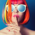 beautiful woman wearing colorful wig and white sunglasses agains