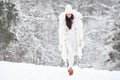 Beautiful Woman Wearing Fashionable Winter Clothes, white down jacket, knitted stylish hat, sweater, leggings, mittens, felt boots Royalty Free Stock Photo