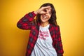 Beautiful woman wearing funny t-shirt with irony comments over isolated yellow background with happy face smiling doing ok sign