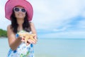 Beautiful woman wearing hat beach and sunglasses and holding starfish Royalty Free Stock Photo