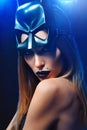 Beautiful woman wearing professional makeup and batman mask