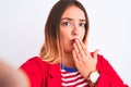 Beautiful woman wearing striped t-shirt and jacket standing over isolated white background cover mouth with hand shocked with Royalty Free Stock Photo