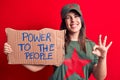 Beautiful woman wearing t-shirt with red star communist symbol asking for social movement doing ok sign with fingers, smiling