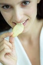 A beautiful woman wearing a towel and a white bathrobe has to eat a snack potato with happy and relaxing on the bed at a