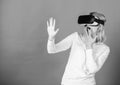 Beautiful woman wearing virtual reality goggles in studio. Confident young woman adjusting her virtual reality headset