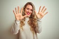 Beautiful woman wearing winter turtleneck sweater over isolated white background showing and pointing up with fingers number ten Royalty Free Stock Photo