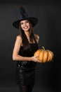 Beautiful woman wearing witch costume with pumpkin for Halloween party on background Royalty Free Stock Photo