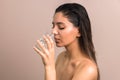Beautiful woman with wet hairs and bare shoulders drinking water from glass. skin care body hydration Royalty Free Stock Photo