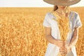 Beautiful woman with wheat spikelets in field on sunny day Royalty Free Stock Photo