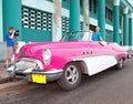 The beautiful woman at a wheel old American retro car (50th years of the last century), an iconic sight in the city, on the Malec Royalty Free Stock Photo