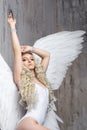 Beautiful woman with white angel wings . blonde in a white swimsuit Royalty Free Stock Photo