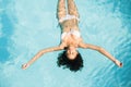 Beautiful woman in white bikini floating in swimming pool