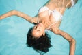 Beautiful woman in white bikini floating in swimming pool Royalty Free Stock Photo