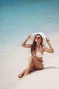 Beautiful woman in a white bikini and hat on the beach. Royalty Free Stock Photo