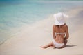 Beautiful woman in a white bikini and hat on the beach. Royalty Free Stock Photo