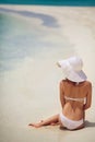 Beautiful woman in a white bikini and hat on the beach. Royalty Free Stock Photo