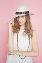 Beautiful woman in white dress posing on pink background in hat Royalty Free Stock Photo